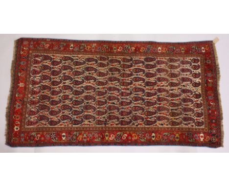 A PERSIAN CARPET, cream ground with Boteh decoration. 260cms x 135cms.