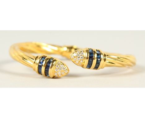 AN 18CT GOLD, DIAMOND AND SAPPHIRE TORQUE STYLE BANGLE. 