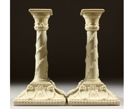 A PAIR OF ROYAL WORCESTER CREAM WARE CANDLESTICKS. Pattern No. 1050. 21cms high.