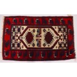 A SMALL PERSIAN RUG, cream ground with bright red ground border. 117cms x 73cms.