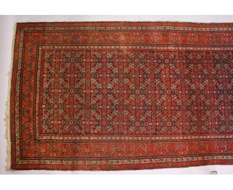 A PERSIAN LONG CARPET, blue ground with stylized geometric motifs, with a similar border. 500cms x 200cms.
