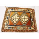 A SMALL PERSIAN RUG, the centre with two large geometric motifs, in a border with stylised tree