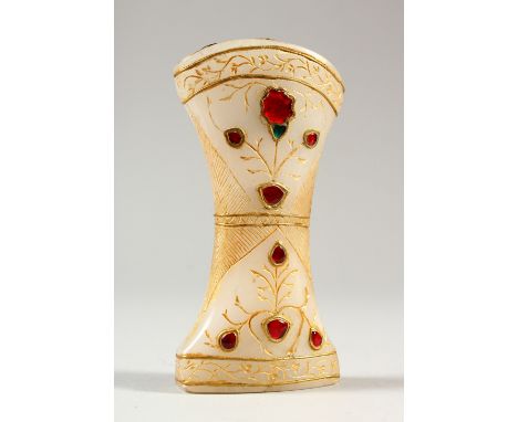 A CARVED AND GILDED WHITE JADE MUGHAL DAGGER HANDLE, with inlaid enamel decoration. 10.5cms long.