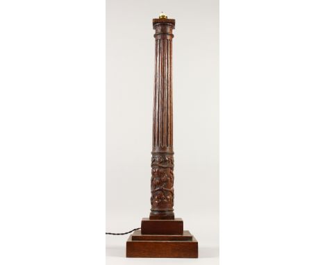 A 19TH CENTURY TURNED AND CARVED WOOD LAMP BASE, on a square base. 74cms high.