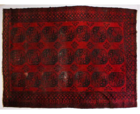 A LARGE PERSIAN BOKHARA CARPET, claret ground with three rows of seven medallions. 320cms x 234cms.