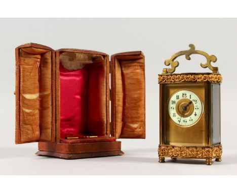 A 19TH CENTURY FRENCH BRASS SERPENTINE SHAPED CARRIAGE CLOCK. 12cms high, in a folding leather case.