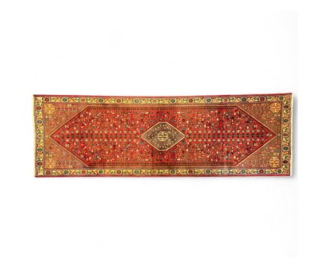 South West Persian Abadeh runner, the red field with a central geometric medallion enclosing stylised hooked motifs, surround