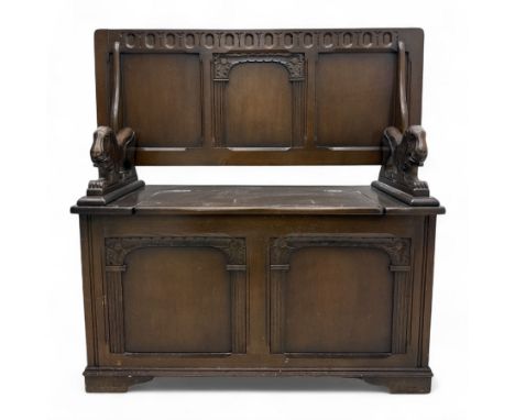 20th century Jacobean design oak monks bench, the panelled back with pierced roundel frieze and arched detail, outswept arms 