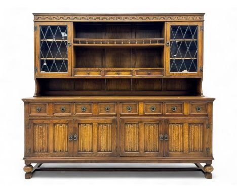 Large mid-20th-century oak dresser with two astragal glazed doors between gallery shelf and lower shelf, with three short dra