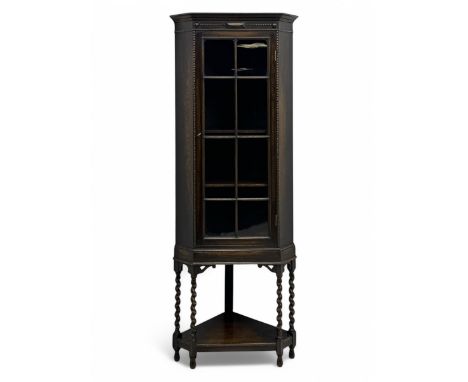 Early 20th century oak corner display cabinet, the moulded canted cornice over a single glazed door with geometric astragal b