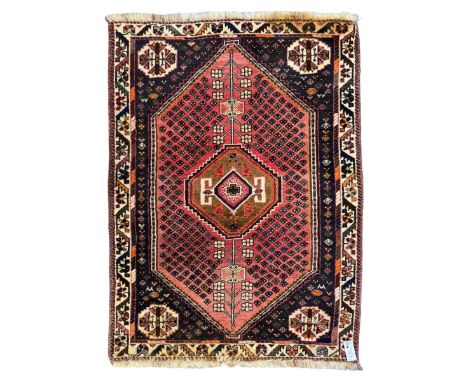 Persian Qashqai rug, hand knotted with geometric central medallion and stylized tree of life motif, pale red and indigo backg