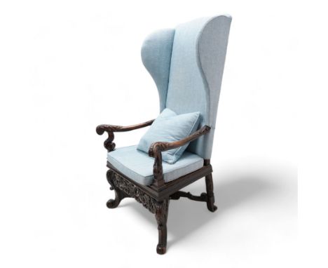 Carolean design walnut and oak wingback open armchair, the high wingback upholstered in light blue herringbone fabric, acanth