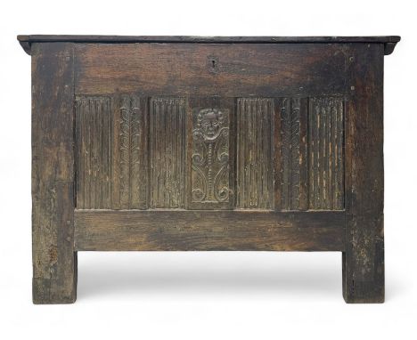 17th century oak coffer, rectangular plank top with iron hinges, front panel carved with central stylised mask motif flanked 