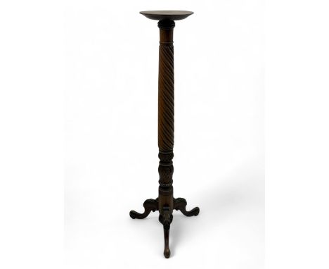 Late 19th century mahogany torchère stand, with circular top above a twisted and foliate carved collumn, on a scroll carved t