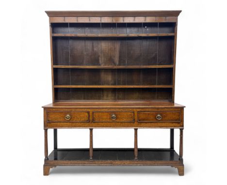 19th-century oak dresser with plate rack, moulded cornice above three shelves with iron hooks, rectangular base above three f