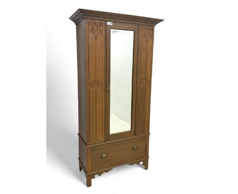 Edwardian oak single wardrobe, with carved Art Nouveau type motifs, with bevelled mirror door between carved panelled doors d