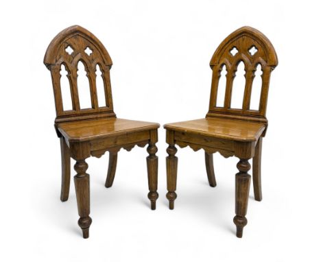 Pair of late 19th-century Gothic revival oak hall chairs, arched back with pierced quatrefoil and vertical lancet decoration 