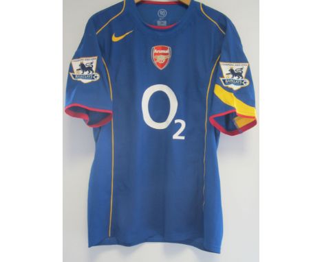 LAUREN ARSENAL MATCH WORN SHIRT      A blue short sleeve shirt with Lauren 12 on the back and Champions 2003-2004 arm flashes