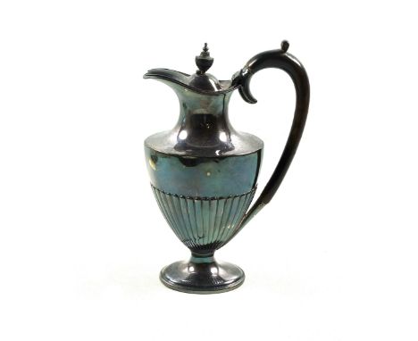 Late Victorian silver hot water jug, of baluster form with semi reeded body, ebonised scroll handle and urn finial, on a step