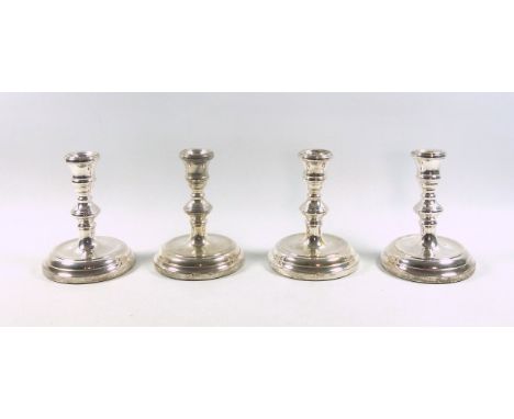 Set of 4 Elizabeth II George III style silver candlesticks, each with a reeded capital, on a knopped cylindrical column, dish