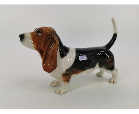PORZELLANFIGUR "Basset", Manufaktur Goebel, Rödental. Stehender Hund in naturalistischer Darstellung und Staffage. H. 17,5 x 