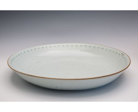 A large Chinese export ceramic charger for the Islamic market white glaze bearing a border of painted green floral stems to o