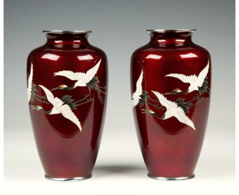 A pair of Japanese Basse Taille enamel red ground vases each with three flying cranes in silver wire cloisons, the silver gro
