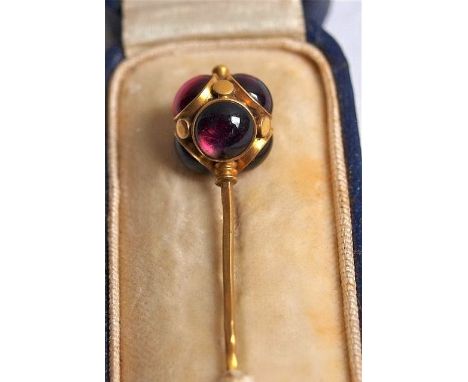 A yellow gold and garnet orb stick pin early 20th century, the square section pin surmounted by an orb set with six armandine