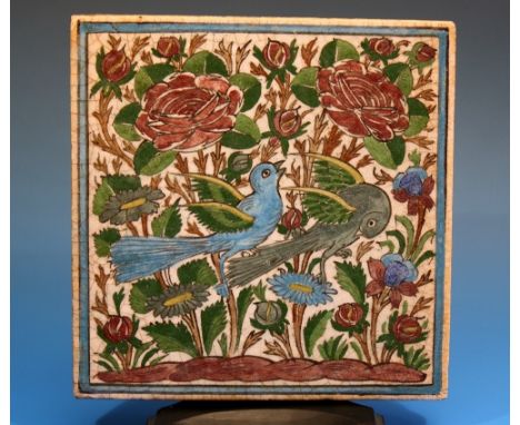 An Iznik ceramic tile probably 18th century, polychrome decoration depicting birds amongst flowering blooms within a blue fra
