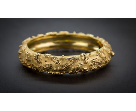 An Elizabeth Gage 18ct satin gold bangle decorated with a raised foliate and bead pattern on a matted satin ground, signed 'G