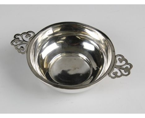 A George V silver tastevin Hamilton & Co., Chester 1922, of plain dished form with twin foliate pierced handles, 4¾in. (12cm.