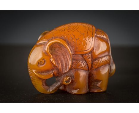 A Japanese carved amber netsuke Meiji period, in the form of an elephant, signed with single character mark to base, 3.7cm. l