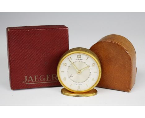 A Jaeger travel alarm clock 1950s, eight day movement within circular satin gilt metal case, Memovox dial signed 'Jaeger 8 Da