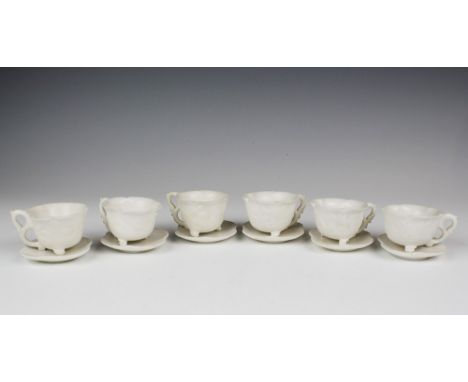 A set of six Chinese carved white stone cups and saucers probably early 20th century, the cups of lotus form with s-scroll dr