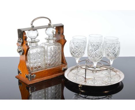 An Edwardian silver plated and oak tantalus, together with an Asprey &amp; Co silver plated tray with wine glass support and 