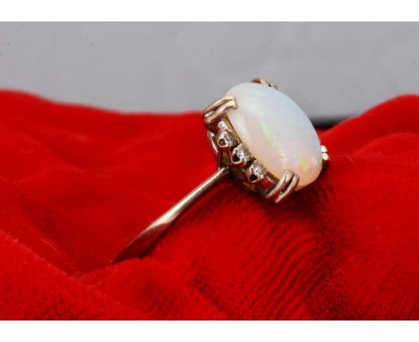 A precious opal and diamond dress ring,  the oval cabochon white opal flanked by eight cuts to the shoulders, ring size Q1/2 