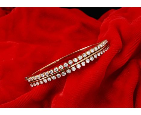 A continental yellow metal and double row diamond hinged bangle,  the double row of brilliant cut diamonds  each approx 0.05c
