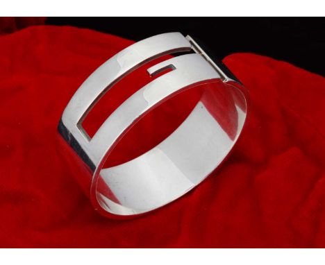 A vintage Gucci silver bangle,  of heavy gauge, with stylised G logo, stamped Gucci Made in Italy 925, original paper label a