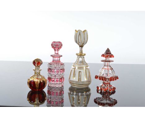 Four pretty cut glass scent bottles, the tallest 18.5cm with flashed white enamel and gilt decoration,