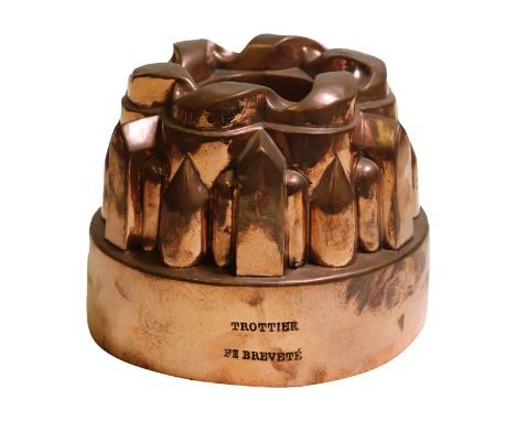 A 19th century French copper circular tiered jelly mould, by Trottier, ribbon scrolled top, over arrangement of pointed arch,