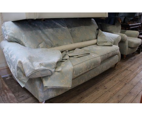 A three seater pale green and cream upholstered sofa with matching armchair