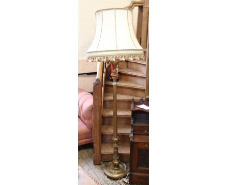 A gold painted standard lamp and shade
