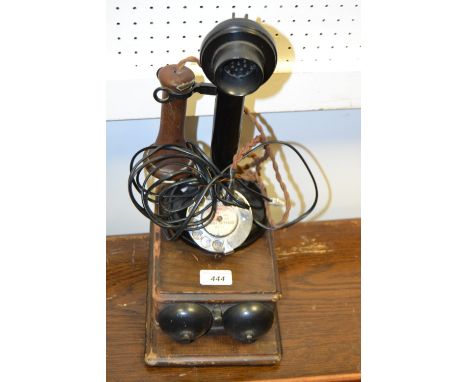 A black stick phone and bell box