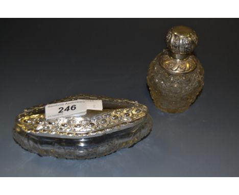 An oval cut glass trinket box with silver lid, 14cm x 7cm (approx), Sheffield 1904; a silver mounted cologne bottle, 9.5cm hi