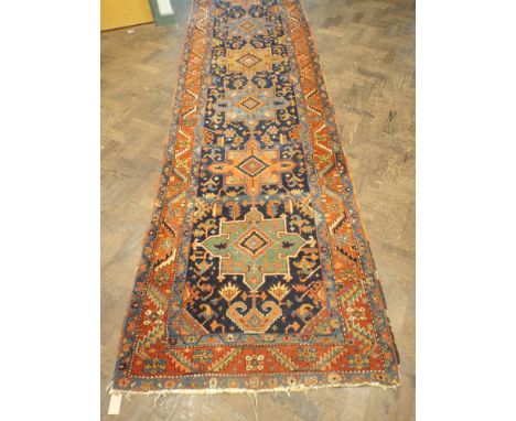 A figured wool pile Persian carpet runner 430cms long, 102cms wide in good condition with frayed fringes  In good condition f