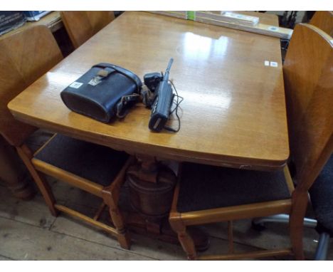 A medium oak draw leaf dining table on bulbous refectory style base together with four panel back chairs with upholstered sea