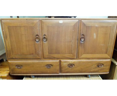 A Ercol elm sideboard fitted three cupboards and two drawers on shepherd castors 51" wide 30" high 