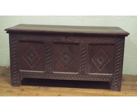 An antique oak three panel carved coffer 120cms wide 