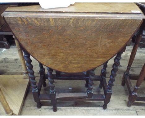 A small oval oak gate leg table on barley twist legs 2' wide 