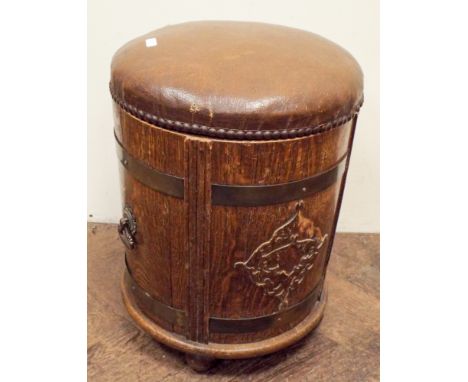 A circular oak fireside stool with brown upholstered top 46cms high 37cms diameter